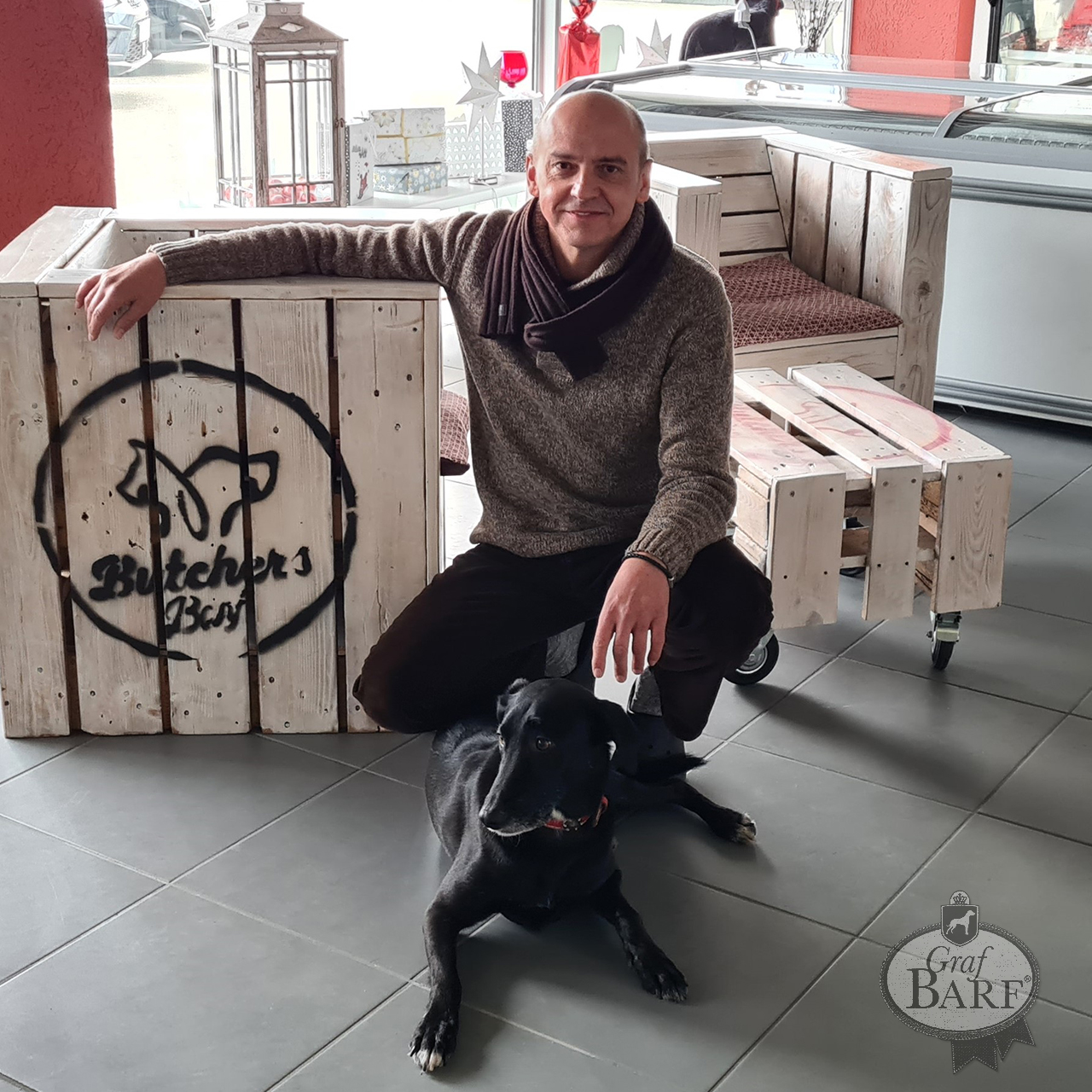 Graf Barf Händler Butcher's Barf Mann sitzt mit Hund auf dem Boden