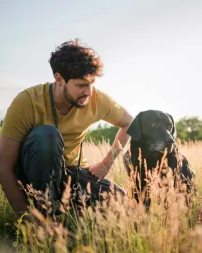 Mann mit Hund auf einem Feld