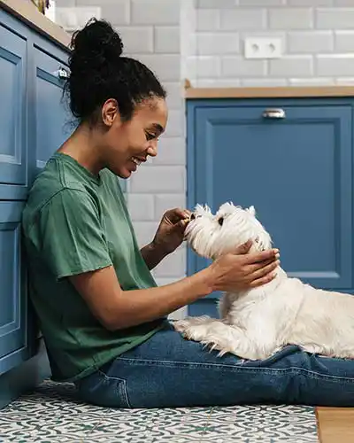 Frau mit Hund in der Küche