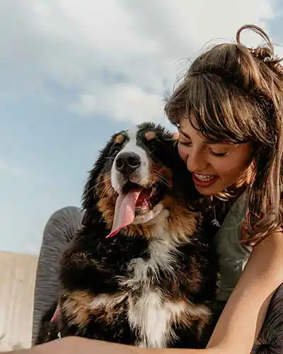 Frau kuschelt mit Hund
